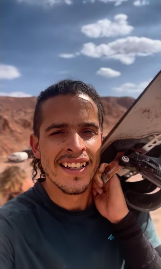 Denver, instructor de sandboard, con su tabla al hombro en las dunas